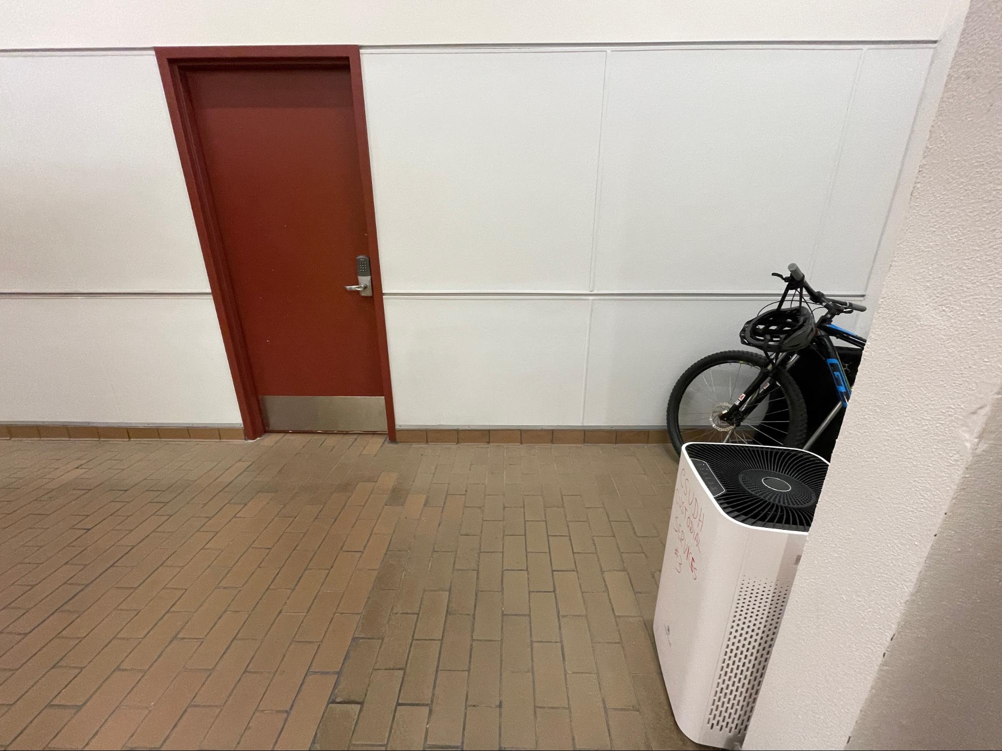 Photo of a white wall with a bike in front of it.