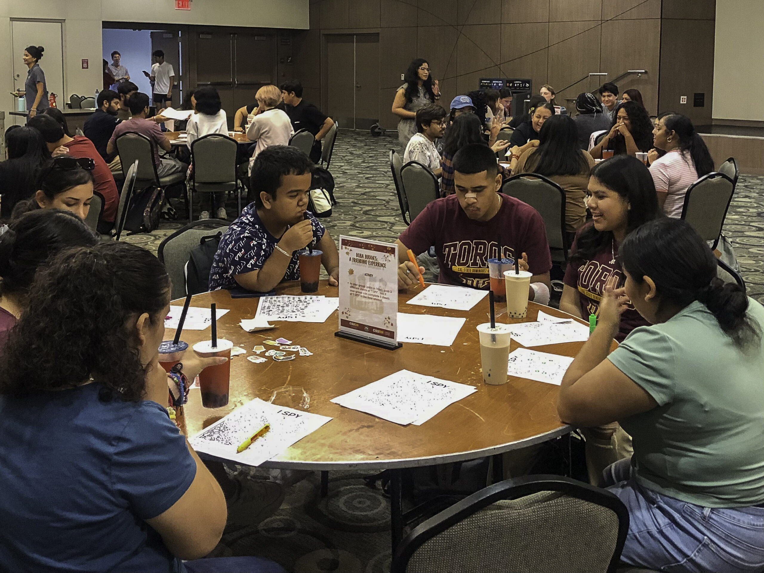 CSUDH students sit around the table drinking boba bubble tea.